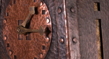 Hammered copper clock with amber mica and brass hands.